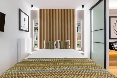 a bedroom with a large bed with a yellow and white headboard at Voukourestiou Grand Residence 56 in Athens