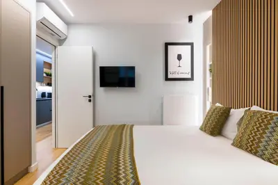a bedroom with a bed and a tv on a wall at Voukourestiou Grand Residence 56 in Athens