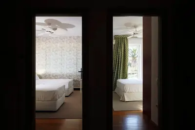 a bedroom with two beds and a ceiling fan at Casa Taylor 4BR with private pool and sea view in Lagonissi