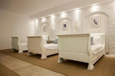 a room with three white beds and chairs at Casa Taylor 4BR with private pool and sea view in Lagonissi