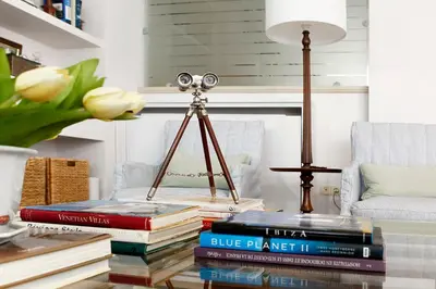 a pile of books sitting on a table with a lamp at Casa Taylor 4BR with private pool and sea view in Lagonissi