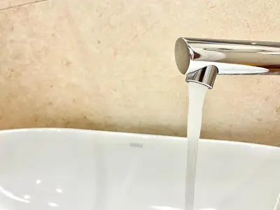 a sink with a running water faucet in a bathroom at Dafne Athens renovated apartment 170m from Metro in Athens