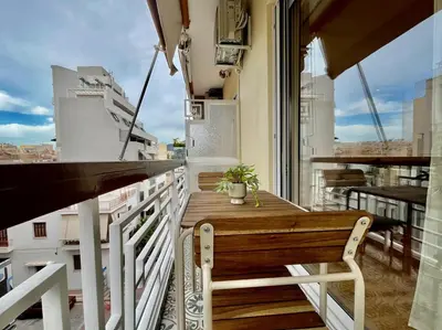 a wooden table on the balcony of a building at Dafne Athens renovated apartment 170m from Metro in Athens