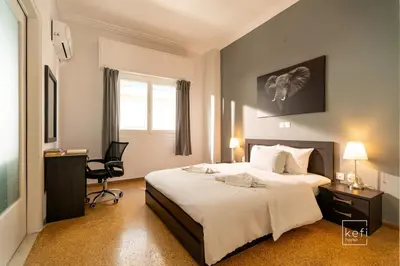 a bedroom with a bed and a desk and a chair at Cozy 3-BDR Flat at Tavros Metro - 10 Min to Center in Athens