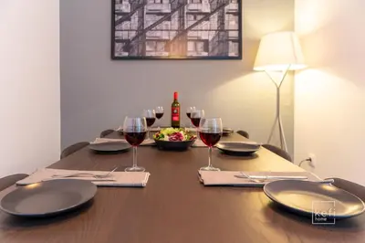 a table with glasses of wine and a bowl of salad at Cozy 3-BDR Flat at Tavros Metro - 10 Min to Center in Athens