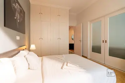 a bedroom with a large white bed with white pillows at Cozy 3-BDR Flat at Tavros Metro - 10 Min to Center in Athens