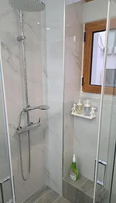 a bathroom with a shower with a glass door at Piraeus Port Rooms in Piraeus