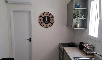 a kitchen with a clock on the wall at Piraeus Port Rooms in Piraeus