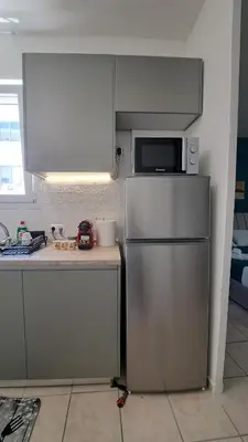 a kitchen with a stainless steel refrigerator and a microwave at Piraeus Port Rooms in Piraeus
