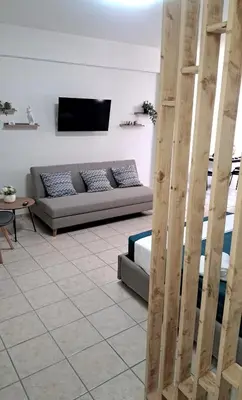 a living room with a couch and a tv at Piraeus Port Rooms in Piraeus