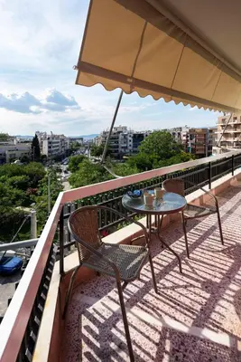 a table and chairs on a balcony with an umbrella at Polis luxury apartment 2 in Athens