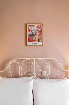 a picture hanging above a bed in a bedroom at Stylish 2BD with Balcony in Central Athens in Athens