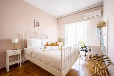 a white bedroom with a white bed and a window at Stylish 2BD with Balcony in Central Athens in Athens