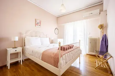 a white bedroom with a white bed and a window at Stylish 2BD with Balcony in Central Athens in Athens