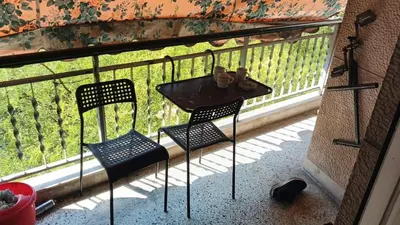 a table and two chairs on a balcony at Acharnon home in Athens