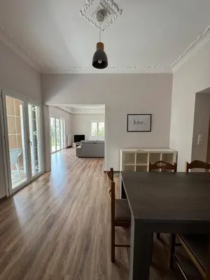an empty living room with a table and a couch at The Ioustinianou Residence in Athens