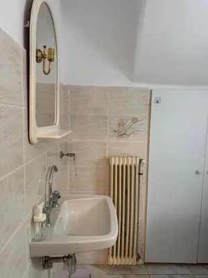 a bathroom with a sink and a mirror and a radiator at The Ioustinianou Residence in Athens