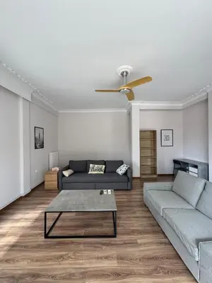 a living room with two couches and a ceiling fan at The Ioustinianou Residence in Athens