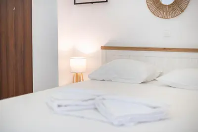 a white bed with white pillows and a lamp at Ble Elia Monastiraki Suite in Athens