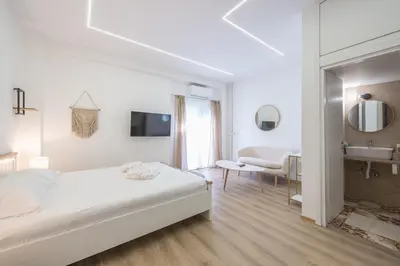 a white bedroom with a bed and a bathroom at Ble Elia Monastiraki Suite in Athens