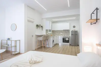 a white room with a kitchen and a bed at Ble Elia Monastiraki Suite in Athens