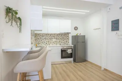 a kitchen with a counter and two chairs in it at Ble Elia Monastiraki Suite in Athens