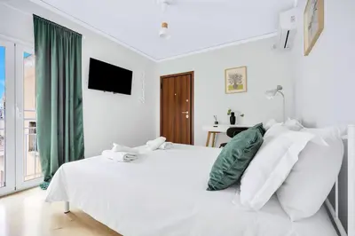 a white bedroom with a white bed and a window at Athens sky & Acropolis view rooftop apartment! in Athens