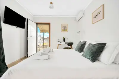 a white bedroom with a large white bed and a desk at Athens sky & Acropolis view rooftop apartment! in Athens