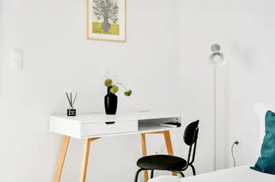 a white desk in a bedroom with a black chair at Athens sky & Acropolis view rooftop apartment! in Athens