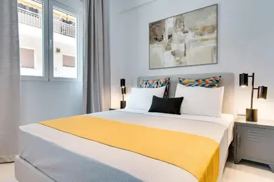 a bedroom with a large bed with a yellow blanket at Honey studio at Kypseli in Athens