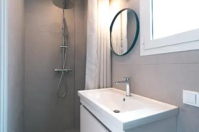 a bathroom with a sink and a shower with a mirror at Honey studio at Kypseli in Athens