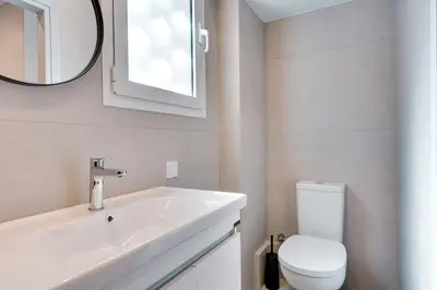 a bathroom with a sink and a toilet and a mirror at Honey studio at Kypseli in Athens