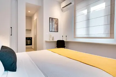 a bedroom with a bed with a window and a chair at Honey studio at Kypseli in Athens
