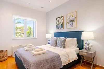 a bedroom with a bed with two towels on it at Stylish 2BR-2BA condo in Glifada in Athens