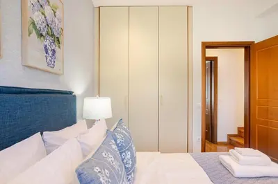 a bedroom with a white bed with a blue headboard at Stylish 2BR-2BA condo in Glifada in Athens
