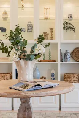 a table with a book and a vase with flowers at Stylish 2BR-2BA condo in Glifada in Athens