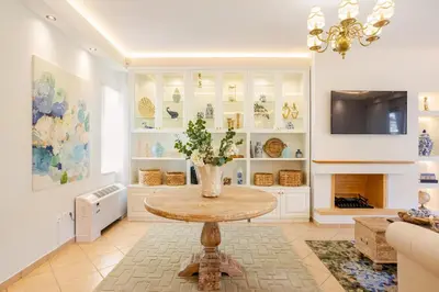 a living room with a table and a fireplace at Stylish 2BR-2BA condo in Glifada in Athens