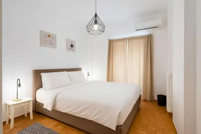 a bedroom with a white bed and a pendant light at 1BR Modern & Cozy Apt Near Metro and Acropolis in Athens