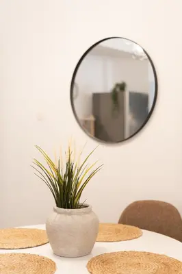 a table with a mirror and a vase with a plant at 1BR Modern & Cozy Apt Near Metro and Acropolis in Athens