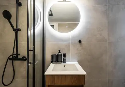 a bathroom with a sink and a shower with a mirror at 1BR Modern & Cozy Apt Near Metro and Acropolis in Athens