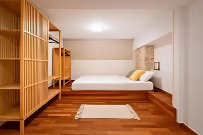 a small bedroom with a white bed and wooden shelves at 2BR Luxurious Apt in Mets 20 min From Acropolis in Athens