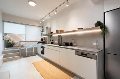 a kitchen with white cabinets and a large window at 2BR Luxurious Apt in Mets 20 min From Acropolis in Athens