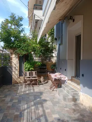 a patio with a table and chairs and a building at SOKRATESg in Athens