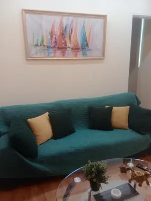 a green couch in a living room with a table at SOKRATESg in Athens