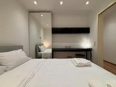 a bedroom with a white bed and a mirror at Cute Detached Home near Glyfada Center in Athens