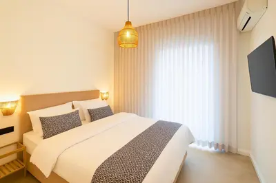 a bedroom with a white bed and a large window at 1BR Stylish Apt Near Metro, 15' From Acropolis in Athens