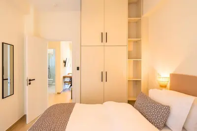 a bedroom with a white bed and a closet at 1BR Stylish Apt Near Metro, 15' From Acropolis in Athens