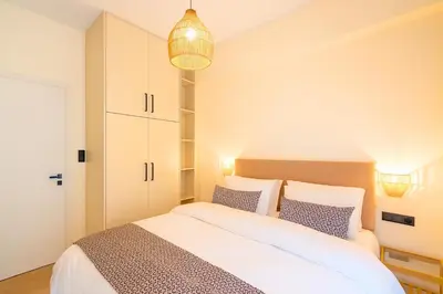 a bedroom with a large white bed with blue pillows at 1BR Stylish Apt Near Metro, 15' From Acropolis in Athens