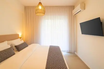 a bedroom with a large bed and a television at 1BR Stylish Apt Near Metro, 15' From Acropolis in Athens