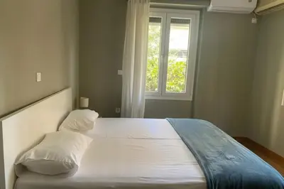 a bedroom with a large bed with a window at Kolonaki Corner -- Bright 2-Bed close to Metro in Athens